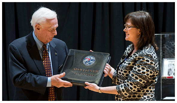 Captain Eugene Cernan presents moon maps to Tracy Grimm of Archives and Special Collections