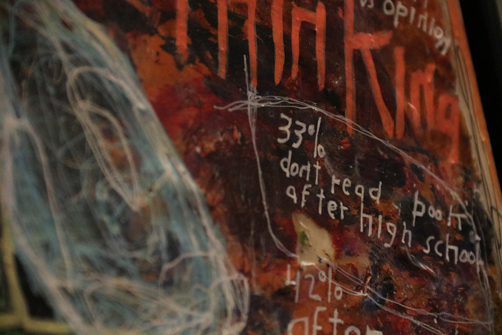 A close-up of a colorful, abstract painting. White handwritten text on the right of the painting reads, "33% don\