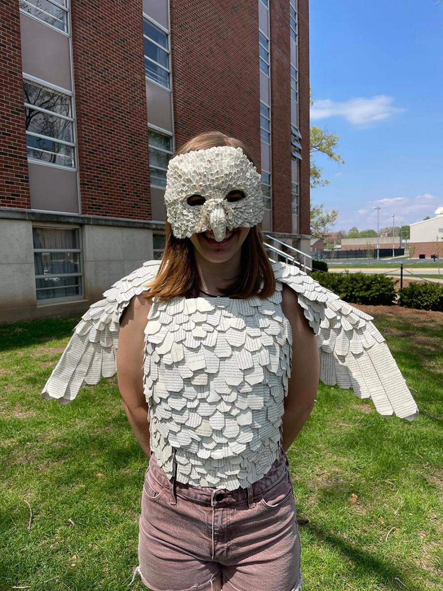 Megan Miltimore modelling the Owl Warrior wearable sculpture. This photo is a front view featuring the half mask, wings, and body with feathers made from book pages.